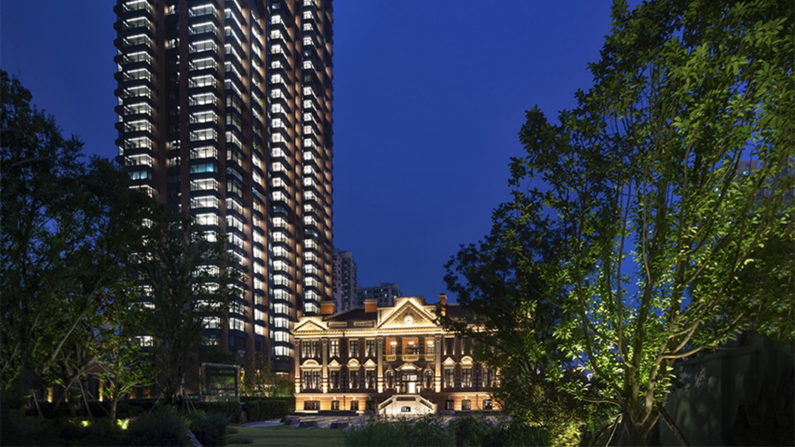 Башня отеля и подсвеченный особняк Шанхайской торговой палаты 1916 года в вечернем саду