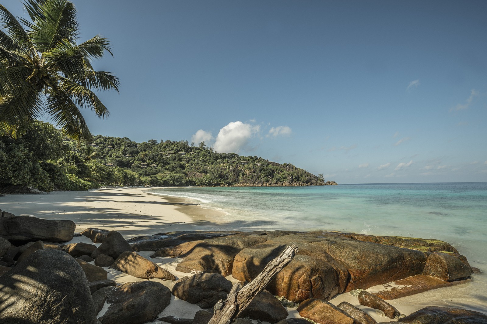 Пляж бухты Petite Anse среди гранитных валунов и пальм