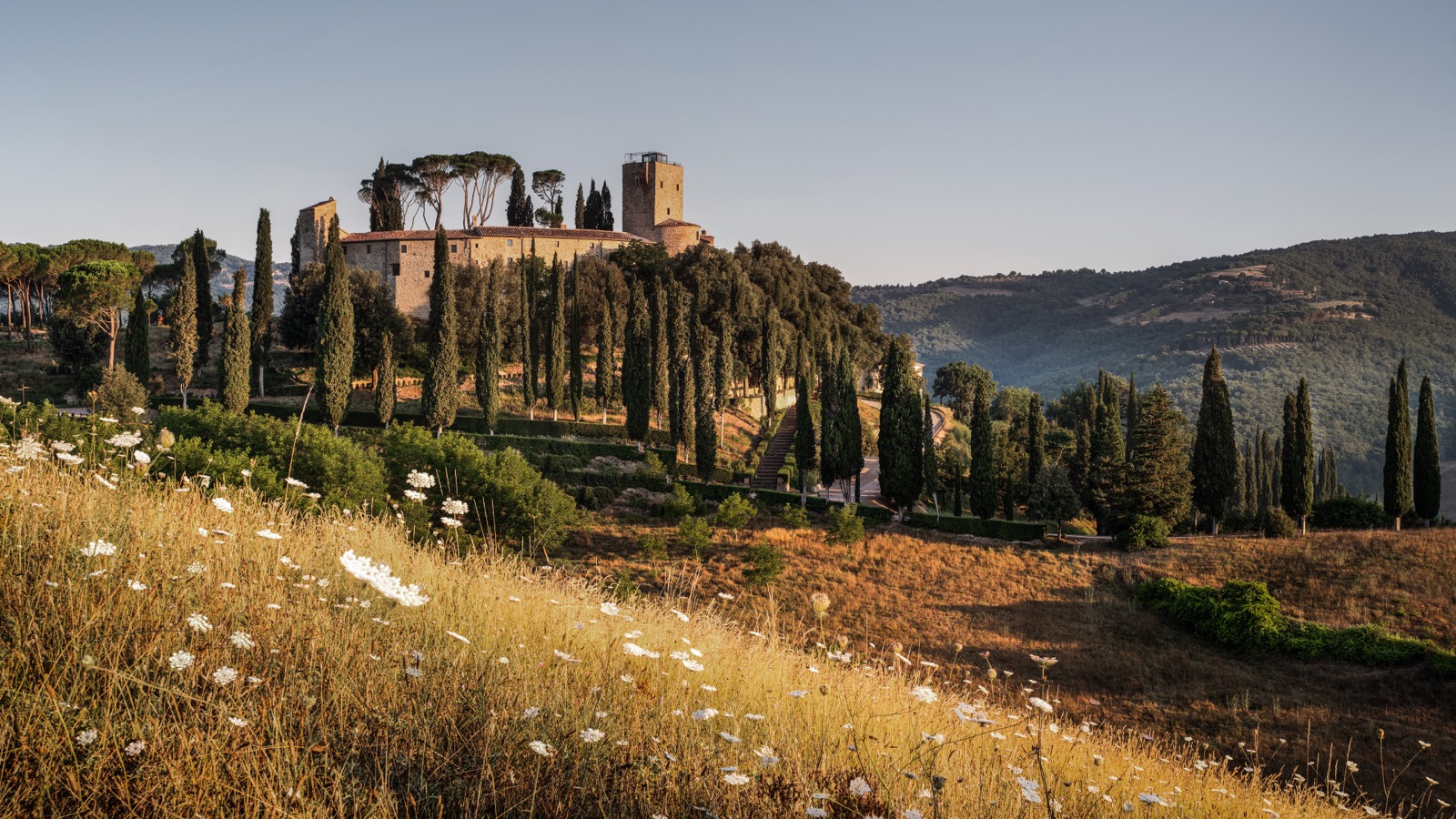 Замок Castello di Reschio на холме среди кипарисов, Умбрия