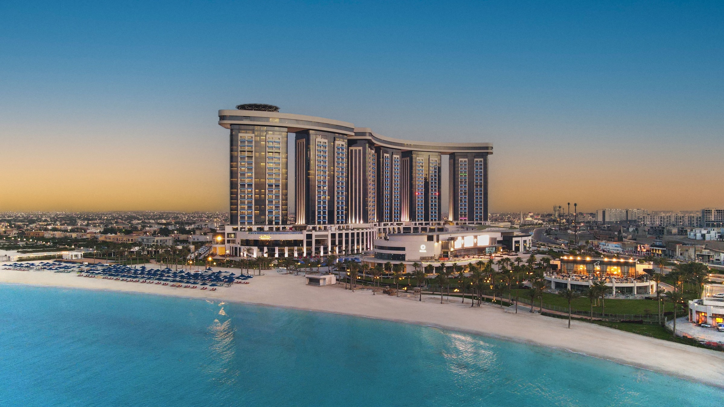 Башни Rixos Premium Alamein и песчаный пляж у моря, вид с высоты