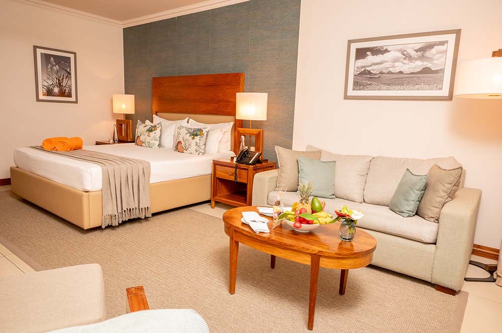 Beachfront Suite: кровать, гостиный уголок и выход к морю
