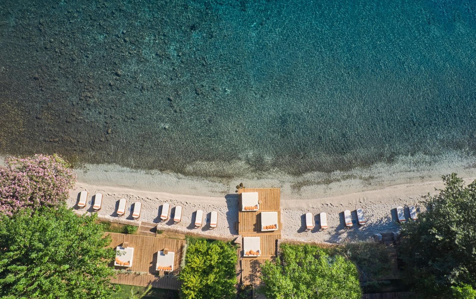 Собственный пляж с шезлонгами и бирюзовая вода бухты